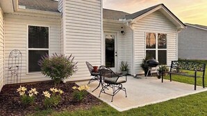 A house with a covered patio, outdoor seating, and a grill. - Brand New Home! Modern Lake Retreat: 1 Mi to Water & Boat Parking (Hartwell)