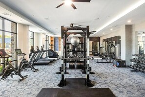 A gym with treadmills, a squat rack, and dumbbells.