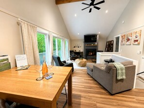 Una sala acogedora con chimenea, un comedor con mesa y sillas, y un sofá.