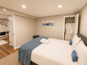 Ein Schlafzimmer mit einem Bett, einem Nachttisch, einem Kleiderschrank und einer Tür zu einem anderen Raum.