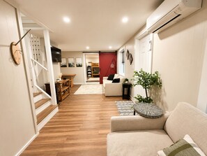 Una sala de estar moderna con un sofá, una mesa de centro y una escalera que lleva a otra habitación.