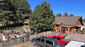 A rustic cabin with a wooden exterior, a fenced yard, and a gravel driveway. - Perfect 2-bedroom cabin in soothing Custer for a relaxing stay. (Custer)
