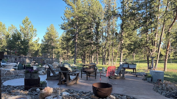 A patio area with outdoor furniture, a fire pit, and a stone fire ring. - Perfect 2-bedroom cabin in soothing Custer for a relaxing stay. (Custer)