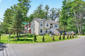 A two-story house with a front porch and a garage. - Pocono Getaway Lake & Pool in Gated Community (Tobyhanna)
