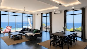 Una sala moderna con un ventanal grande, un sofá, una mesa de centro y un comedor.