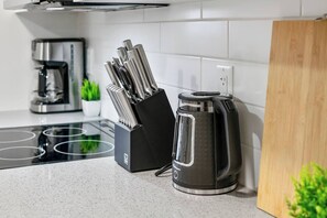 Eine Küche mit Kaffeemaschine, Wasserkocher und einem Messerblock.