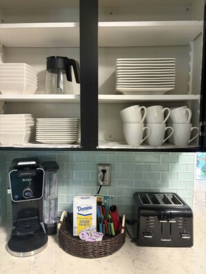 Cuina amb cafetera, torradora i una cistella de sobres de sucre Domino.