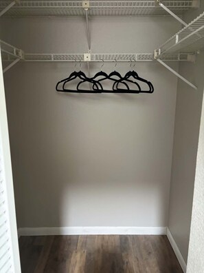 Ein Kleiderschrank mit Kleiderstange und Haken zum Aufhängen von Kleidung.