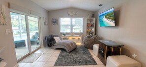 Ein modernes Schlafzimmer mit Bett, Sitzsack, Schreibtisch und Fernseher.