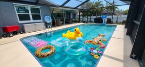 Ein Schwimmbecken mit verschiedenen aufblasbaren Spielzeugen und einer roten Schubkarre.