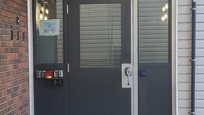 En svart skjutdörr med ett säkerhetskodlås och en titthål.