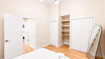 Ein Schlafzimmer mit einem Bett, einem Kleiderschrank und einem Spiegel.