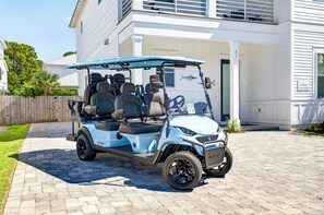 Ein Golfmobil steht vor einem Haus mit einem gepflasterten Einfahrt.