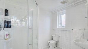 Een badkamer met toilet, wastafel en douche.