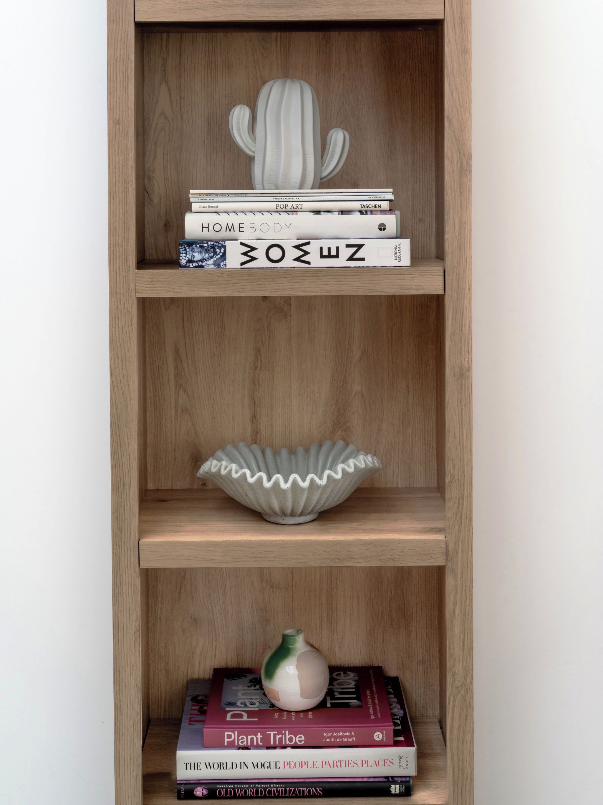 Ein Bücherregal aus Holz mit Büchern und Dekoration.