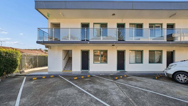 A multi-story building with a parking area in front. - Murrays Beach Studio (Sawtell)