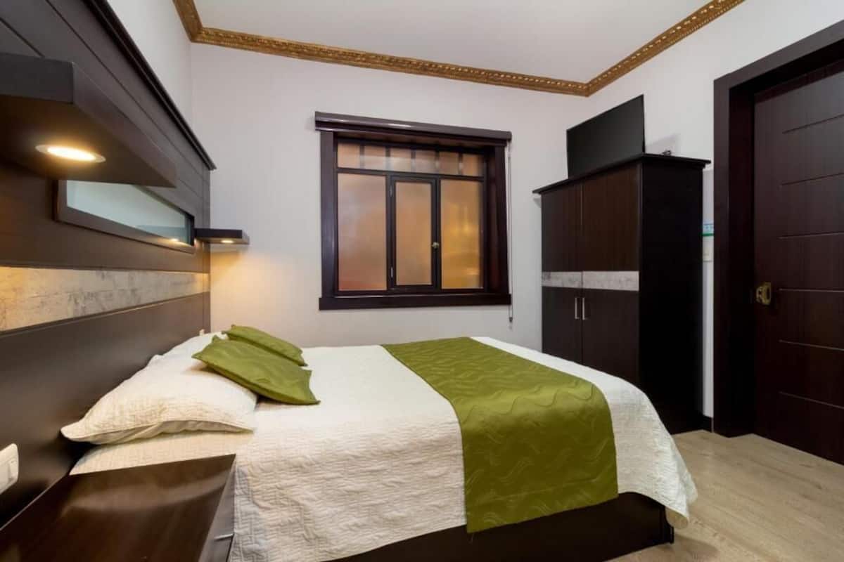 Espacio para trabajar con un portátil y tabla de planchar con plancha