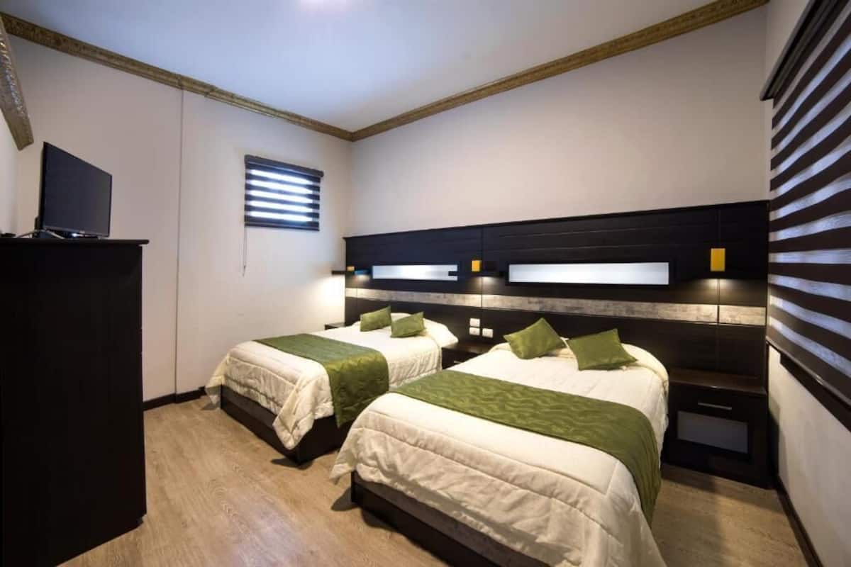 Habitación cuádruple Confort | Espacio para trabajar con un portátil y tabla de planchar con plancha