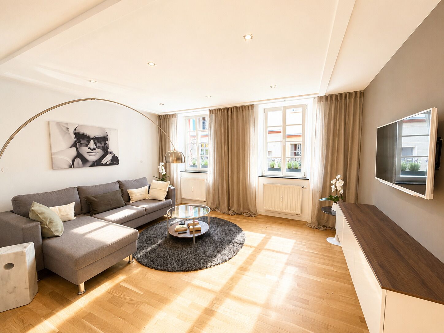 A modern living room with a sofa, coffee table, and a mounted TV.
