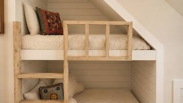 Letto a castello multistrato con struttura in legno, ripiano inferiore e materasso con cuscino decorativo.