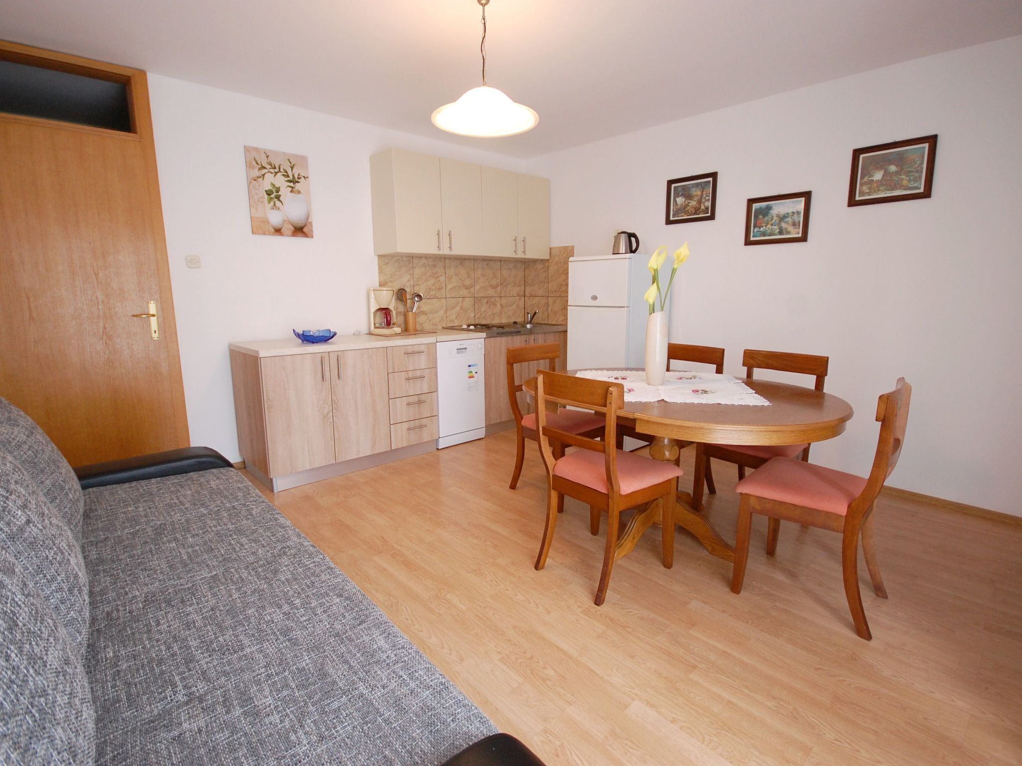 A compact living space with a kitchenette, dining area, and a sofa.