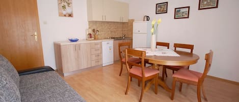 A compact living space with a kitchenette, dining area, and a sofa.