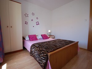 Un dormitorio con una cama, una mesita de noche y un armario.