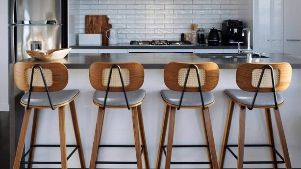 A modern kitchen with white subway tiles, stainless steel appliances, and wooden bar stools. - Ocean-View Apartment in Heart of Portarlington (Portarlington)