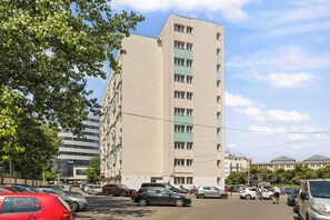 A multi-story building with a parking lot in front. - North Station Studio w. AC (Bucharest)