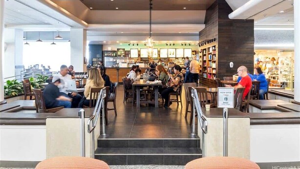 En Starbucks Coffee med indendørs siddepladser og udsigt over byen.