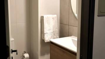 Un bagno piccolo con WC, lavandino e doccia.