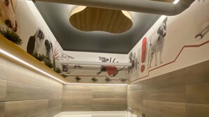 Ein modernes Badezimmer mit einer großen Badewanne, einer Holzbank und einer Decke mit runden Leuchten.
