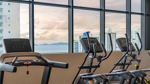 A gym with treadmills and a stationary bike, large windows with a city view. - Serviced Studio with City & Ocean View in Panama U902 (Panamá)