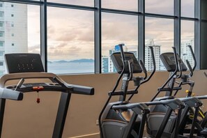 A gym with treadmills and a stationary bike, large windows with a city view. - Serviced Studio with City & Ocean View in Panama U902 (Panamá)