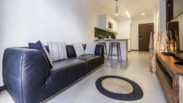 Uma sala de estar moderna com sofá, mesa de centro e espaço para bar.