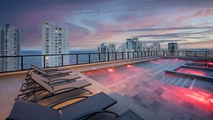 A rooftop pool with lounge chairs and a city skyline view. - Service Studio with Ocean Views in Panama City (Panamá)