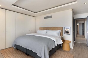 Ein Schlafzimmer mit Bett, Kleiderschrank, Nachttisch und einem gerahmten Bild an der Wand.