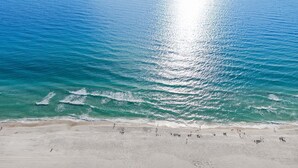 Ein Strand mit klarem türkisblauem Wasser und einem sandigen Ufer.