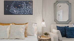 Ein Hotelzimmer mit einem Bett, einem Sofa, einer Lampe und einem Gemälde an der Wand.
