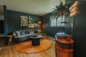 Un salon avec un canapé, une table basse et une platine vinyle.