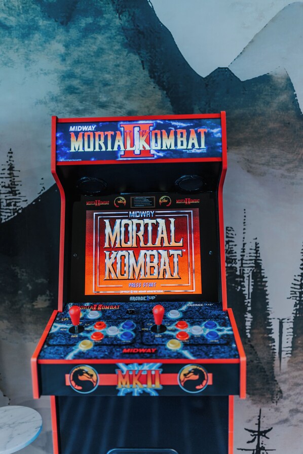 A Mortal Kombat arcade machine with a mountainous background.
