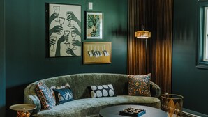 Una sala de estar moderna con un sofá, una mesa de centro y una obra de arte en la pared.