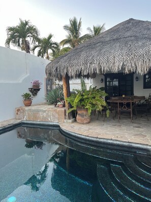 A pool with a tiled edge, a thatched roof structure, and potted plants. - Los Cabos Retreat
3/3 home, 24 Hr. security, private pool gated compound (San José del Cabo)