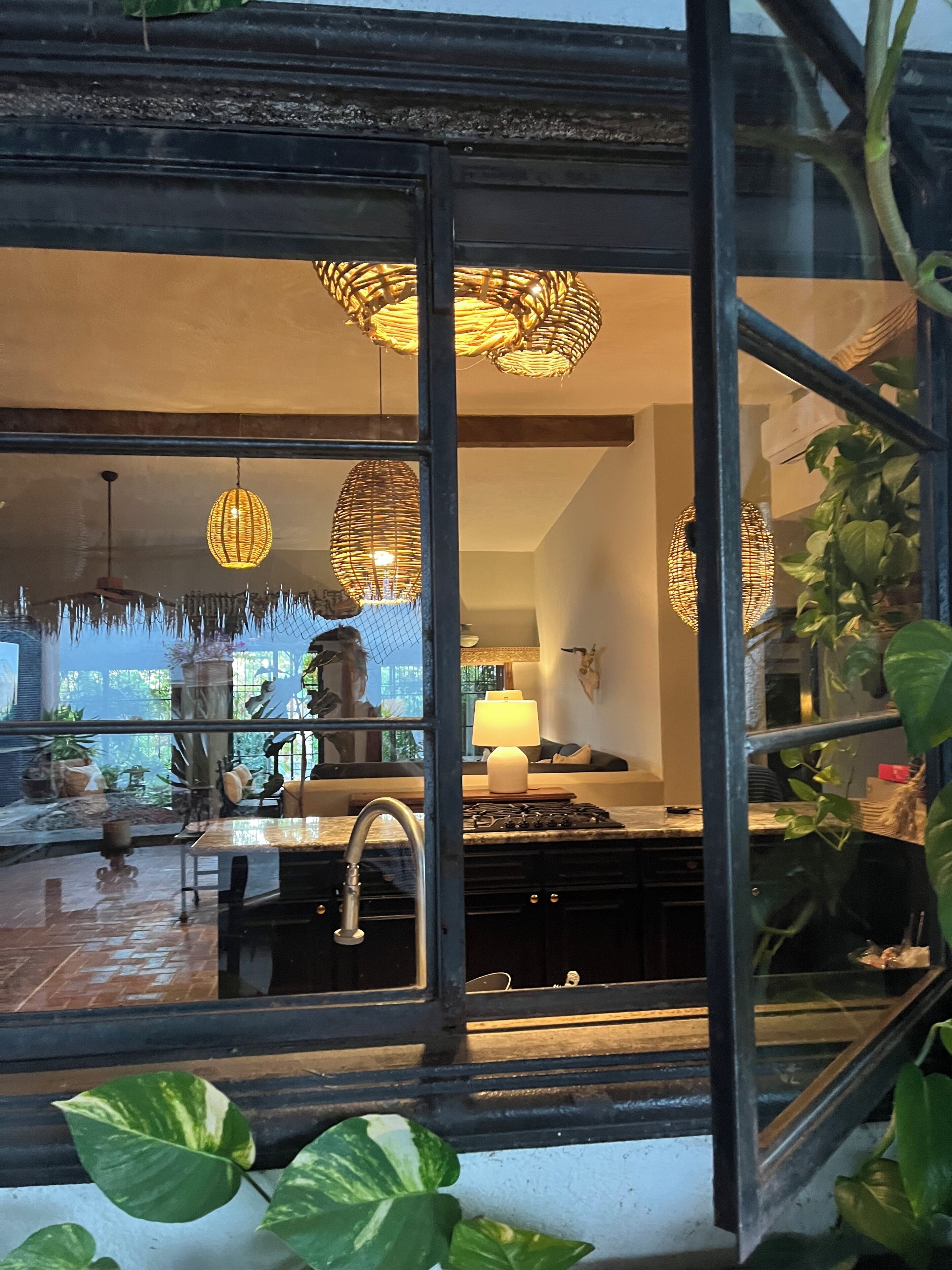 A kitchen with a sink, a stove, and hanging lights.