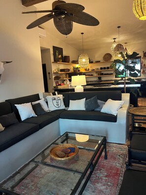 A modern living room with a sectional sofa, a glass coffee table, and a ceiling fan. - Los Cabos Retreat
3/3 home, 24 Hr. security, private pool gated compound (San José del Cabo)