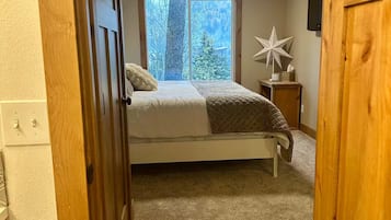 A bedroom with a bed, a window, a star decoration, and a nightstand.