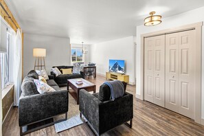 Un salon comprenant un canapé, une table basse, un téléviseur et une lampe.