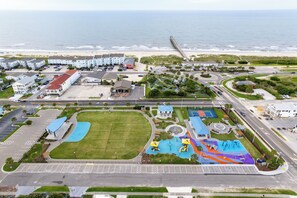 Ein Küstenresort mit Parkplatz, Schwimmbad und Strand.