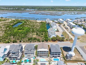 A coastal hotel with multiple buildings, a large water tower, and a marina.
