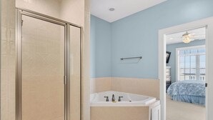 A bathroom with a shower, a bathtub, and a window. - Spacious 7-bedroom Beach House in fantastic Ocean Isle Beach w/ Private Pool&AC (Ocean Isle Beach)